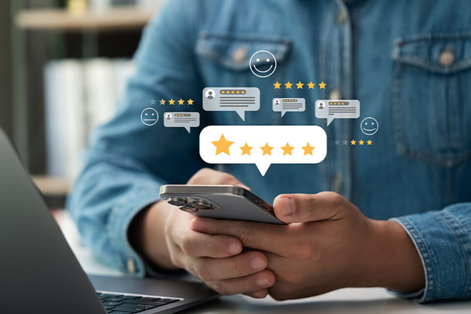 Person holding smartphone with floating star ratings and review icons, representing online credibility, trust signals, and customer testimonials for SEO