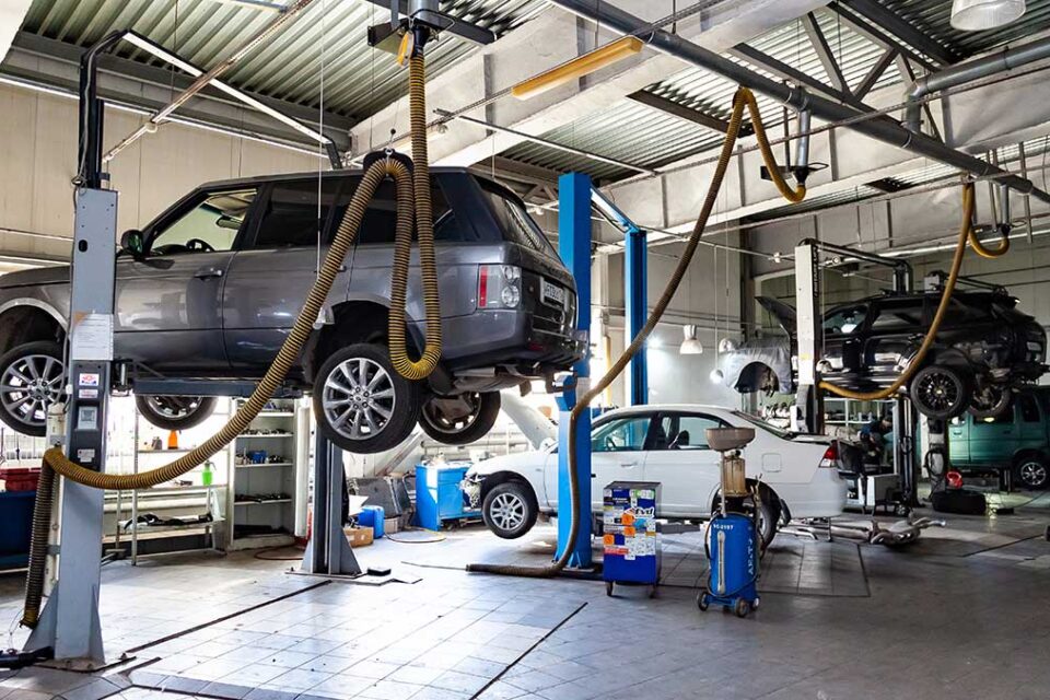 Land Rover vehicles on hydraulic lifts at a euro mechanic shop in Tampa Bay