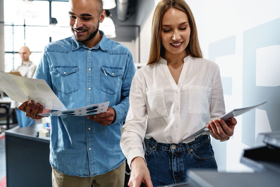 Office workers using Epson multifunction printer for color print materials in modern business environment