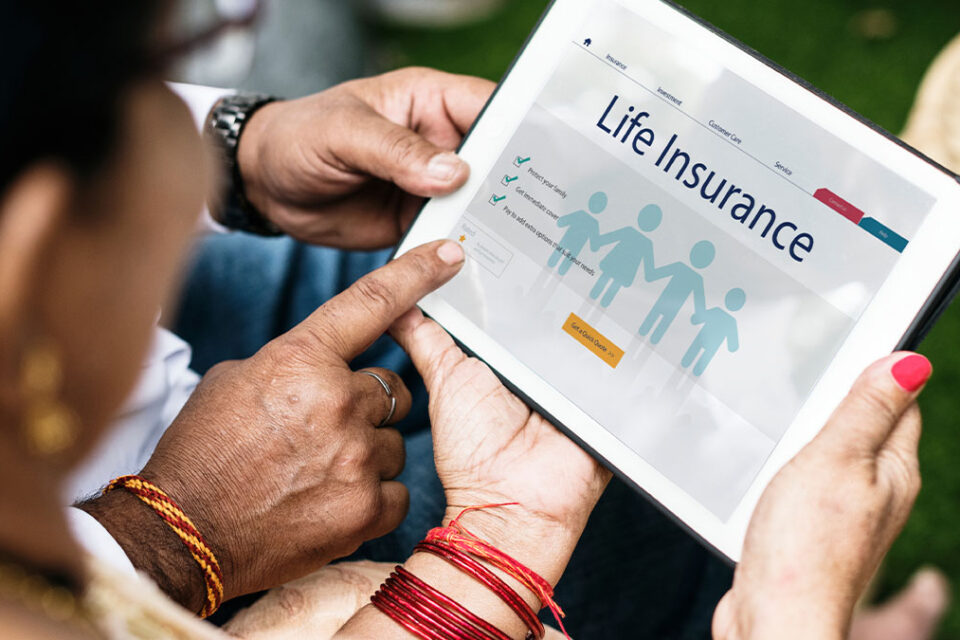 Mature woman looking down at a mobile tablet device displaying a life insurance policy